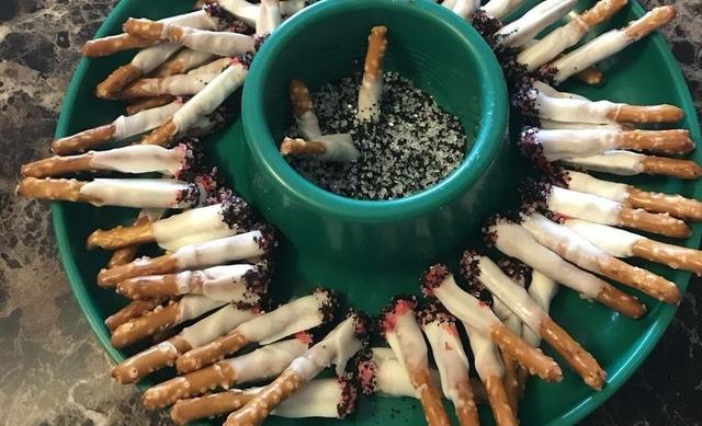 Salzstangen in weiß-roter Schokolade mit schwarz-weißen Zuckerstreusel